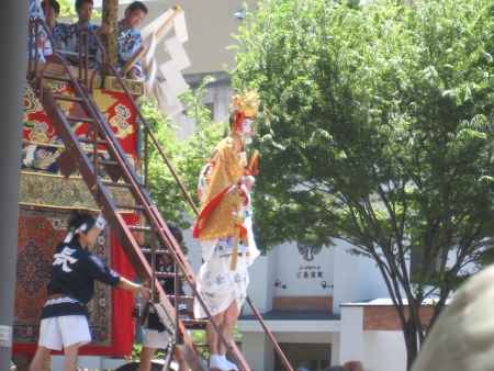 強力の肩に乗って降りてくる長刀鉾の稚児