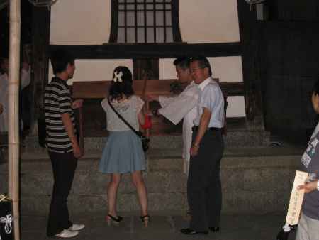 迎鐘のつき方を教わる女性